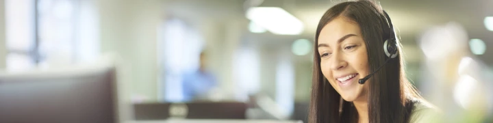 Eine junge Callcenter-Mitarbeiterin nimmt einen Anruf entgegen