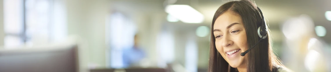 Eine junge Callcenter-Mitarbeiterin nimmt einen Anruf entgegen